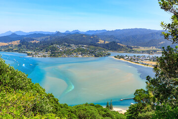 Fototapeta premium The sunny holiday town of Tairua on the Coromandel Peninsula, New Zealand. Panoramic view of the town and Tairua Harbour from Mount Paku