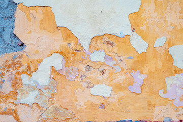 damaged weathered multicolored coating of paint of concrete building wall with many patches