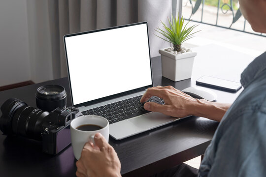 a man work at home and drinking a cup of coffee and using a laptop computer