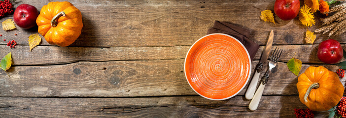 Autumn background for Thanksgiving day. Pumpkin, fruits apples, autumn leaves on rustic wooden table. Autumn table settings. Fall seasonal decoration.Top view, copy space