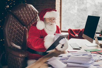 Photo of hard-working grey hair santa claus prepare x-mas christmas sit table write clip board...