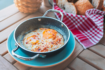 Breakfast sunny side up eggs with seasoning on copper pan