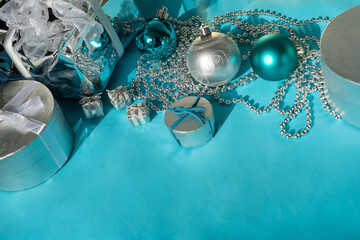 Christmas decorations and gifts with ribbons on blue table with copy space
