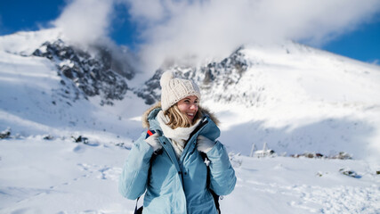 Fototapeta na wymiar Portrait of happy smiling woman standing in snowy winter nature.