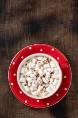 Cocoa with marshmallows in a red Cup and gingerbread on a tray on a Christmas background.  Christmas Flatly. Top view from copyspace	