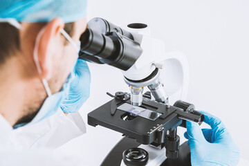 Scientist looks through a microscope in a laboratory. Medical and pharmaceutical concept....