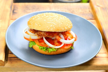 The burgers are in a gray ceramic plate on a wooden table.