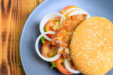 The burgers are in a gray ceramic plate on a wooden table.