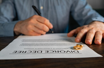 Husband signing decree of divorce agreement prepared by lawyer. - obrazy, fototapety, plakaty