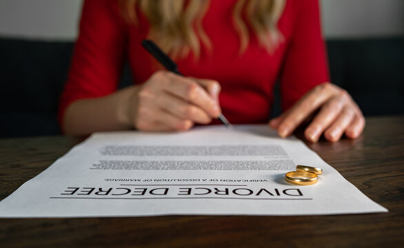 Wife signing decree of divorce agreement prepared by lawyer.