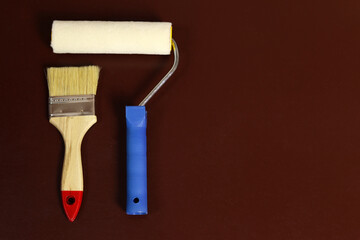 Painting tools - brush, roller on a dark brown background, copy space for text