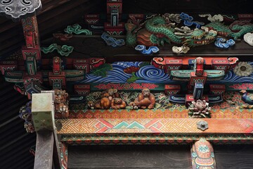 Colorful shrine wood carving decoration at Chichibu Jinja Shrine in Chichibu, Saitama, Japan. Dragon, Kiji bird and three monkeys.