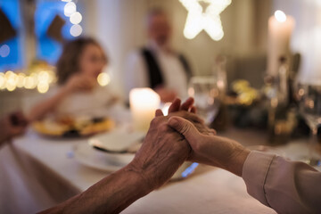 Close-up of hands holding together at the table at Christmas.