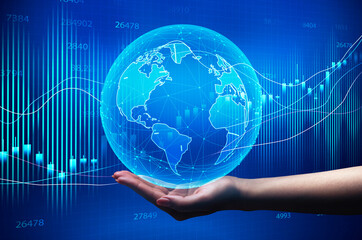 Hand Holding Globe Over Blue Background With Global Economy Graphs