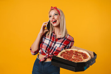 Image of joyful pinup girl talking on cellphone while holding pizza