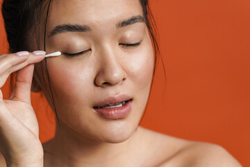 Fototapeta premium Image of beautiful shirtless asian girl using cotton swab