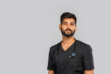 young indian male doctor or surgeon with stethoscope on gray background