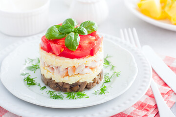 Festive layered salad with fried champignons, smoked chicken, eggs and cheese, garnished with fresh tomatoes, selective focus