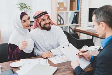 Obraz premium Family sits at a table in front of realtor smiling