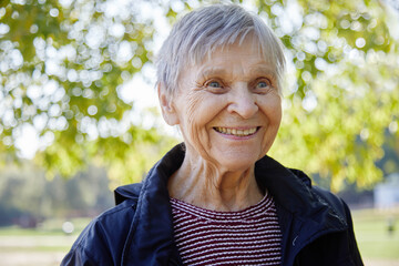 Portrait of ninety year old woman is smiling in the park.