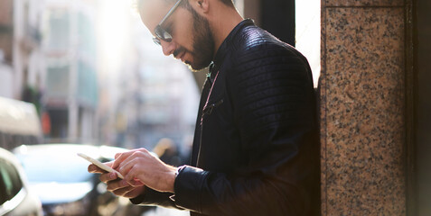 Stylish man using phone in city