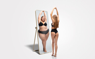 Young fit, slim woman looking at fat girl in mirror's reflection on white background. Thinking...