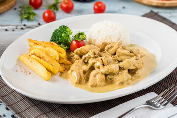 Chicken Curry Sauce. Served with rice. Natural wooden background.