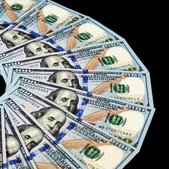 Close-up of US dollars fanned out on a black background. There are a lot of bills on the entire image surface