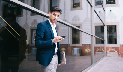 Young businessman with laptop using phone