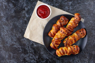 Scary sausage mummies in dough for kids party. Funny crazy Halloween food for children.