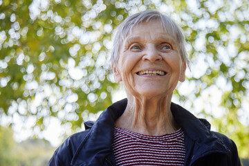 Portrait of ninety year old woman is smiling in the park.