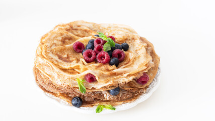 Tasty homemade crepes with berries and honey.  Pancakes with berries