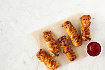 Scary sausage mummies in dough for kids party. Funny crazy Halloween food for children.