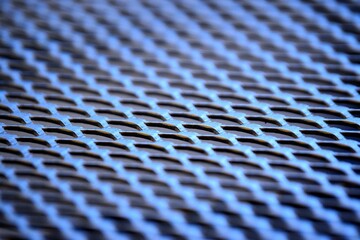 abstract view of a photographer on the lattice structure of a metal chair seat in a black design for an outdoor setting