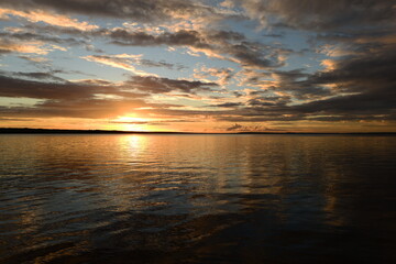 Shadows and sunlight of sunset on lake water in sky reflection