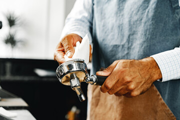 Unrecognizable man barista preparing coffee on professional coffee machine