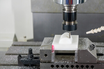 The  CNC  milling machine cutting  the engineering plastic parts by solid endmill tool. The...