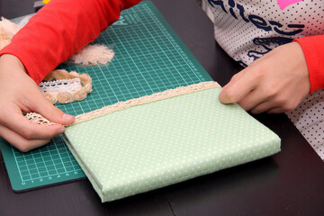 A child decorates the cover of a notebook.