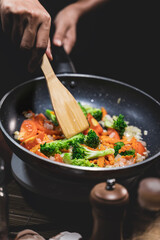 Close up,Young women cooking fried mixed vegetables.