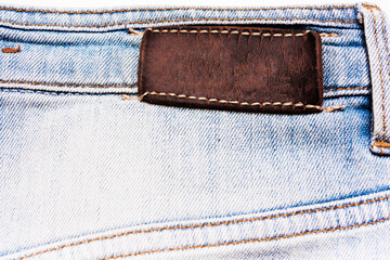 Denim light blue fabric. Texture about with a leather label.