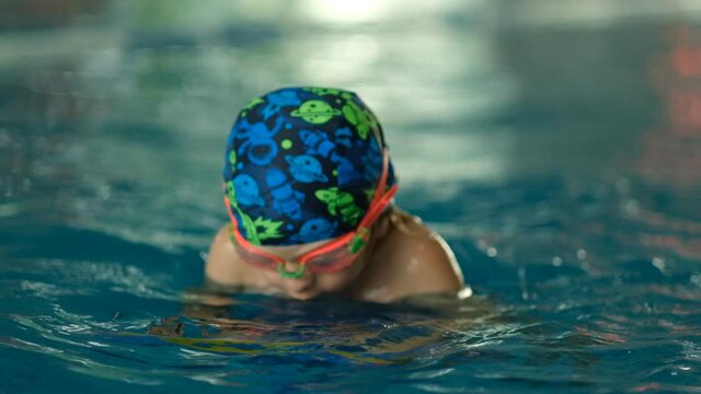 Future champion. Swimming training for the little champion. Little cute boy strengthens his health by swimming in the pool.