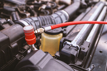 servicing car air conditioner in repair workshop with soft-focus and over light in the background