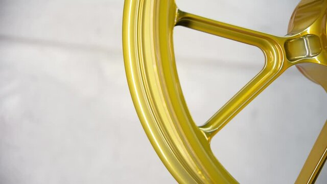 Golden Motorcycle Wheels in Paint Booth &ndash; Custom Bike Refinishing