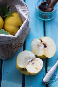 A halved quince on a turquoise wooden board