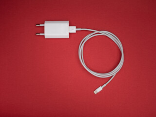 USB charger on red background, top view