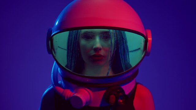 Woman in space helmet. Multi-colored neon lighting.