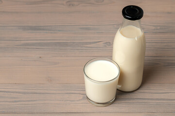 Glass bottle of milk on wooden table