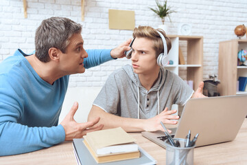 Obraz premium Dad pushed back his son’s earpiece. 