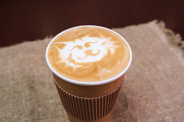 Delicious, aromatic and refreshing cappuccino coffee with a cat pattern in a disposable plastic cup