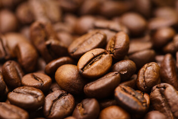 Detail view of roasted coffee beans, with out of focus background.